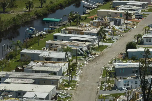 Property damage from strong hurricane winds. Mobile homes in Florida residential area with destroyed rooftops. Consequences of natural disaster.
