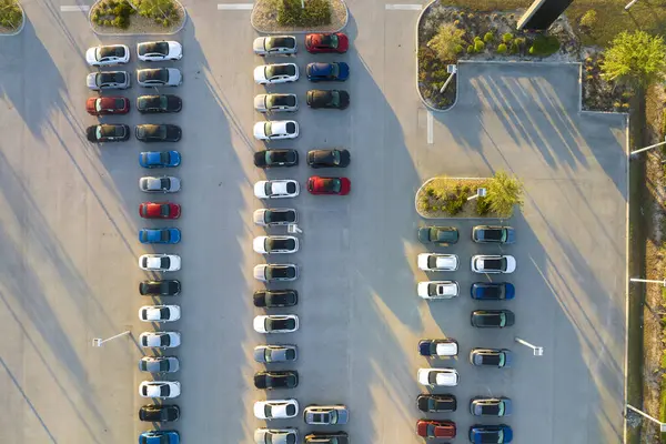 Large parking lot of local dealer with many brand new cars parked for sale. Development of american automotive industry and distribution of manufactured vehicles concept.