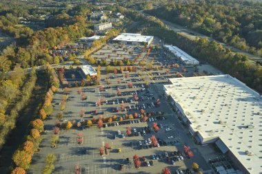 Hava manzaralı alışveriş merkezi ve park yerinde park yerleri ve yönler için çizgiler ve işaretler olan bir sürü renkli araba. Bir alışveriş merkezinin önünde araçlar için yer.