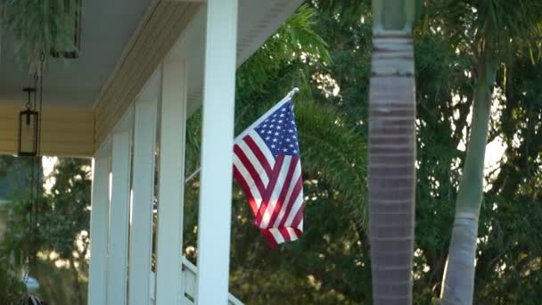 フロリダのプライベートハウスの前庭で振るアメリカの国旗 アメリカのスターやストライプの空中ビュー 民主主義のシンボルとしてのバナー — ストック動画