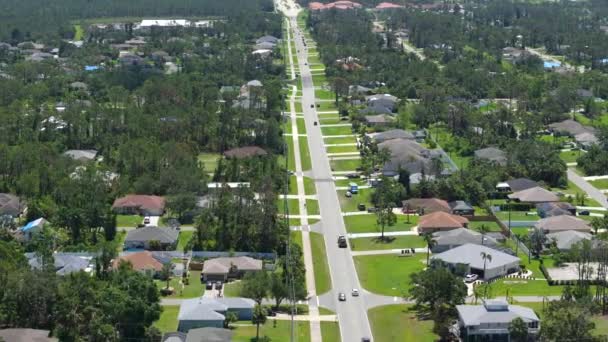 フロリダの小さな町で車を運転する農村の道路交通 静かな住宅地のプライベートハウスを持つアメリカの郊外風景 — ストック動画