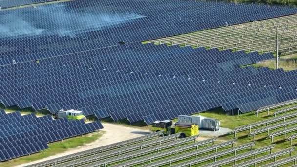 在有一排太阳能光电面板的大型发电厂燃烧草坪的空中景象 以产生清洁的电能 可再生电力设施的防火安全概念 — 图库视频影像