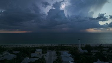 Okyanus kıyısında karanlık evleri ve deniz feneri olan bir sahil kasabası fırtınalı bir gecede ticari gemilerin seyrüsefer için yanıp sönen bir ışık. Deniz üzerinde şimşekler çakan fırtına gemiler için tehlike arz ediyor..