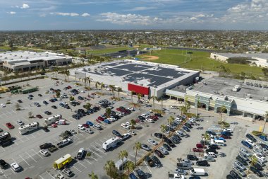 Park etmiş bir sürü arabası olan büyük bir otopark. Alışveriş merkezindeki büyük otopark. Araç yerleri ve yönleri için çizgiler ve işaretler var..