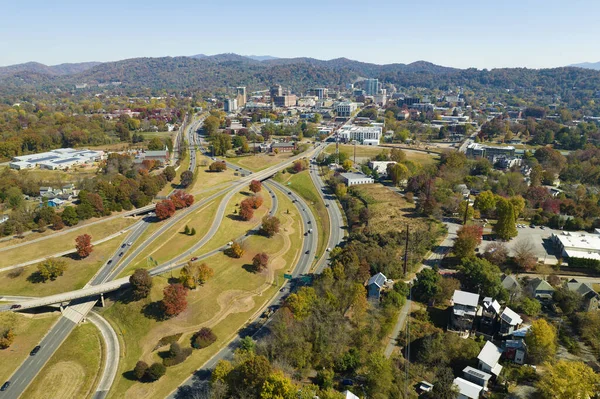 American freeway intersection in Asheville, North Carolina with fast driving cars and trucks in autumnal season. View from above of USA transportation infrastructure.