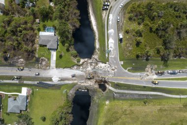 Yol çalışması alanında inşaat malzemeleri. Sel suları asfaltı yıkadıktan sonra yıkılan hasarlı yol köprüsünün yeniden inşası. Yıkılmış ulaşım altyapısının yeniden inşası.
