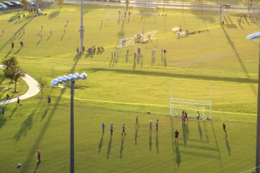 Okul çocuklarının gün batımında futbol oynadığı bir stadyum. Aktif yaşam konsepti.
