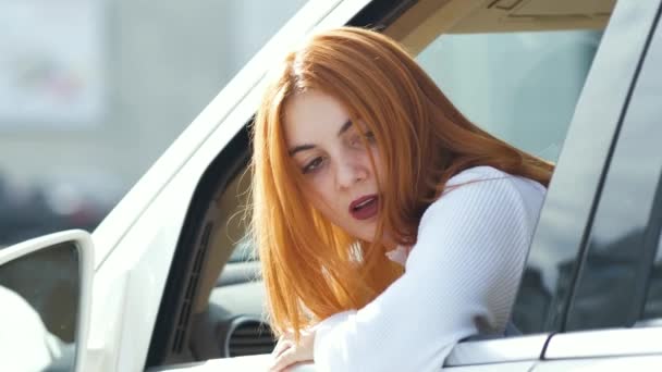 年轻的红头发女司机开车向后看去 — 图库视频影像