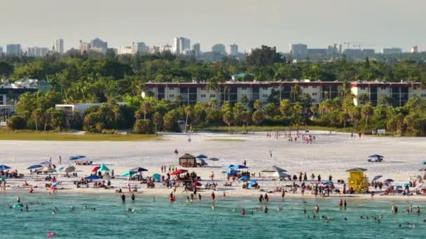 米国サラソータ州の観光客でいっぱいの白い砂を持つシエスタキービーチの上からの眺め 暖かいフロリダの日差しで水泳とリラックスで休暇時間を楽しむ多くの人々 — ストック動画