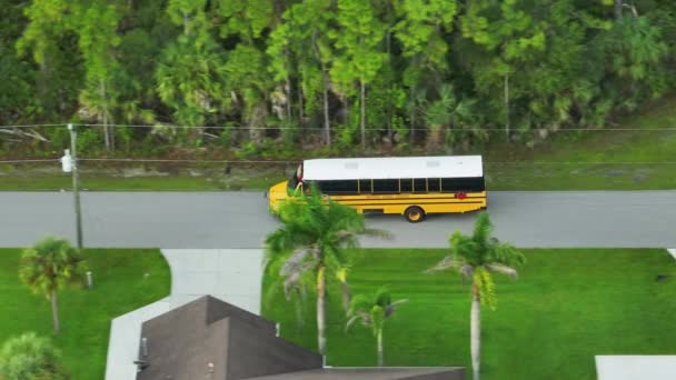 アメリカの黄色いスクールバスが郊外の通りに運転し 早朝に子供たちをレッスンに連れて行った アメリカの公共交通機関 — ストック動画