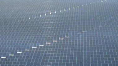 Temiz elektrik enerjisi üretmek için sıra sıra güneş fotovoltaik panelleri olan sürdürülebilir büyük elektrik santralinin havadan görünüşü. Sıfır emisyonlu yenilenebilir elektrik kavramı.