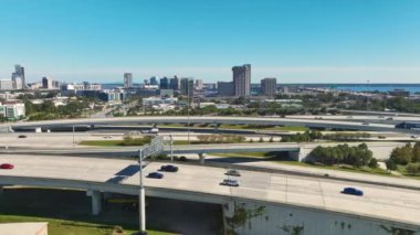 Jacksonville şehrinin hava manzarası. Yüksek ofis binaları ve hızlı araba ve kamyonlarla Amerikan otoyolu kavşağı. ABD ulaşım altyapısının üstünden görüntüle.