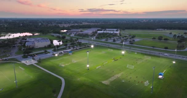日落时 人们在灯火通明的体育场上踢足球 积极的生活方式概念 — 图库视频影像
