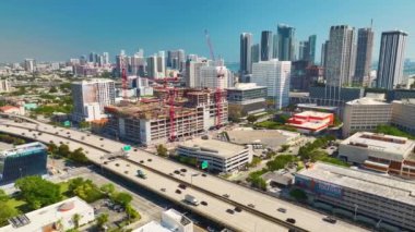 Miami kentsel bölgesinde gayrimenkul geliştirme. Geniş şeritli otoyolun yakınındaki yüksek konutlu inşaat alanındaki vinçler kaldırılıyor..