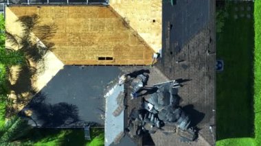 Çatıdan eski asfalt kiremitlerin çıkarılması. İnşaat işçileri çatı kaplamasını değiştiriyor. Florida 'daki evin tamiri. Gayrimenkul geliştirme kavramı.