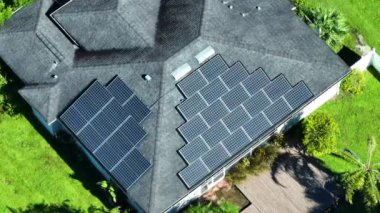 Temiz ekolojik elektrik enerjisi üretmek için mavi güneş fotovoltaik panelleri olan Amerikan ev çatısı. Emeklilik geliri için yenilenebilir elektriğe yatırım.