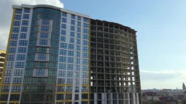 High residential apartment building with monolithic frame and glass windows under construction. Real estate development.