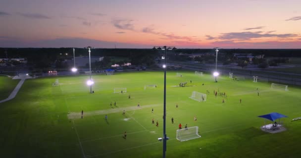 フロリダ州ノースポートの公共スポーツアリーナを照らし サッカーの試合をサッカー場で夕日を過ごす人々と共に アウトドア活動コンセプト — ストック動画