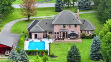 Arka bahçesinde büyük bir yüzme havuzu olan lüks bir banliyö evi ve New York 'un taşrasında yaz mevsiminde yeşil çimenli bir çim. Rochester, New York 'ta kırsal kesimde özel bir ev..