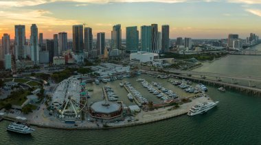 Bayside Pazarı 'ndaki hava manzaralı Miami Gözlem Çarkı Biscayne Körfezi suyunda yansımalar ve Brickell' in aydınlık gökdelenlerinde günbatımında finans merkezi.