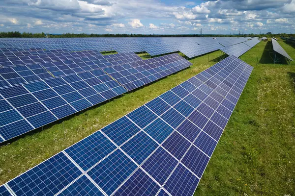 Temiz elektrik enerjisi üretmek için birçok sıra güneş fotovoltaik paneli bulunan sürdürülebilir büyük elektrik santralinin havadan görünüşü. Sıfır emisyon kavramı ile yenilenebilir elektrik.