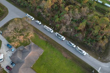 Elektrik işçileri Florida yerleşim bölgesindeki kasırga üstüne kova kamyonları kullanarak hasar görmüş elektrik hatlarını onarıyor..