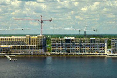 Yüksek konutlu apartman şantiyesinde vinç kaldırma. Deniz kıyısında gayrimenkul geliştirme.