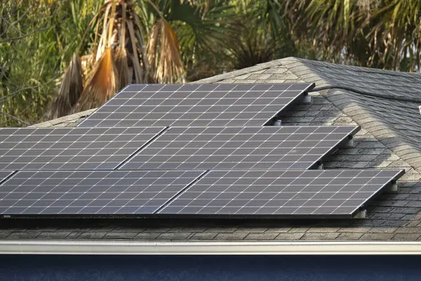 Banliyö bölgesinde temiz ekolojik elektrik enerjisi üretmek için güneş fotovoltaik panellerle kaplı çatısı olan bir ev. Özerk konut kavramı.