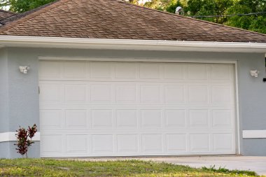 Wide garage double door and concrete driveway of new modern american house.