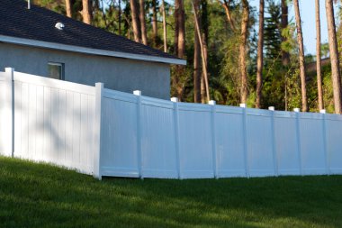 White plastic fence for back yard protection and privacy.