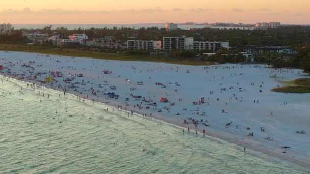 サラソータ 米国のシエスタキービーチの空中ビュー 多くの人々は 湾岸の水で泳いだり 日没時に暖かいフロリダの太陽の下でリラックスして休暇を楽しんでいます — ストック動画