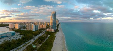 Günbatımında Atlantik Okyanusu kıyısında lüks oteller ve konutlarla Sunny Isles Beach 'in hava manzarası. Güney Florida 'daki Amerikan turizm altyapısı.