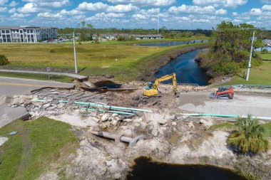 Florida 'da kasırga üstüne köprü yıkıldı. Yol çalışması alanında inşaat malzemeleri. Sel sularının asfaltı temizlemesinden sonra hasarlı yolun yeniden inşası.