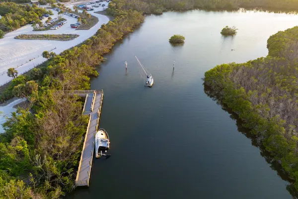 stock image Capsized sunken sailing boat left forsaken on shallow bay waters after hurricane Ian in Manasota, Florida.