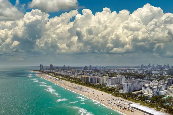 Güney Sahili 'nin kumlu yüzeyi. Sıcak Florida güneşinde dinlenen turistler. Güney Amerika 'da turizm altyapısı. Yüksek lüks otelleri ve apartmanları olan Miami Beach City..