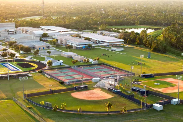 Sports facilities at public school in Florida, USA. American football stadium, tennis court and baseball diamond sport infrastructure.