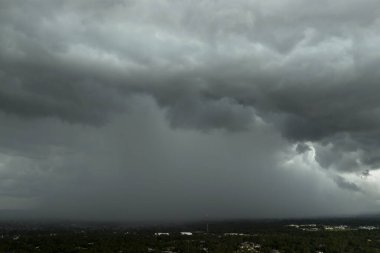 Fırtınalı kümülüs bulutları karanlık gökyüzünde sağanak yağış sırasında oluşuyor. Hareket eden ve değişen bulutlu hava durumu.