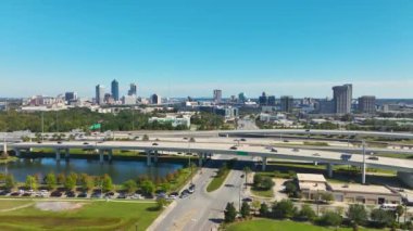 Jacksonville şehrinin hava manzarası. Yüksek ofis binaları ve hızlı araba ve kamyonlarla Amerikan otoyolu kavşağı. ABD ulaşım altyapısının üstünden görüntüle.