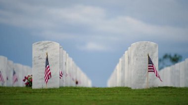 Yeşil çimlerin üzerinde beyaz mezar taşları olan Amerikan ulusal mezarlığı. Anma Günü konsepti.