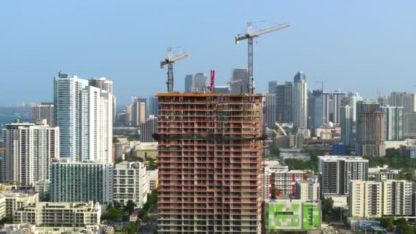 アメリカの都市部に住宅開発の新しい建設現場 フロリダ州マイアミでクレーンを持ち上げる工業タワー アメリカにおける住宅成長の概念 — ストック動画