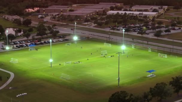 公共スポーツパークの照明スタジアムでサッカーをするスポーツマン — ストック動画