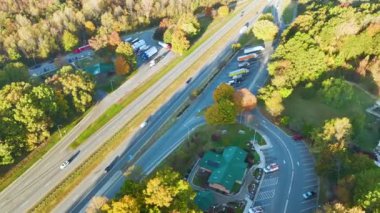 Top view of large rest area near busy multilane American freeway with fast moving cars and trucks. Recreational resting place during interstate traveling.