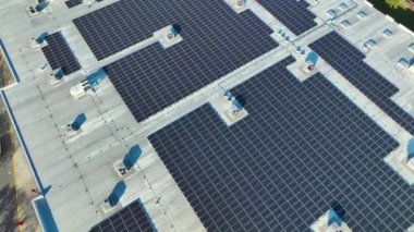 Mavi fotovoltaik güneş panelleri yeşil ekolojik elektrik üretmek için sanayi binasının çatısına monte edildi. Sürdürülebilir enerji konsepti üretimi.