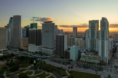 Miami Brickell 'in şehir merkezinin hava görüntüsü, Florida, ABD gün batımında. Modern Amerika 'da arabaları ve metro trafiği olan yüksek gökdelen binaları ve caddeleri.