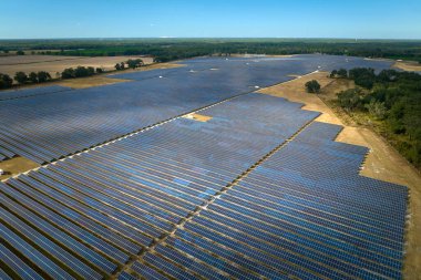 Temiz elektrik enerjisi üretmek için birçok sıra güneş fotovoltaik paneli bulunan sürdürülebilir büyük elektrik santralinin havadan görünüşü. Sıfır emisyon kavramı ile yenilenebilir elektrik.