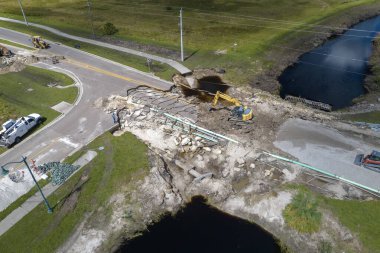 Florida 'da kasırga sonrası yıkılan köprünün tamiri. Su baskınından sonra hasarlı yolun yeniden inşası asfaltı yıkadı. Yol çalışması alanında inşaat ekipmanları.