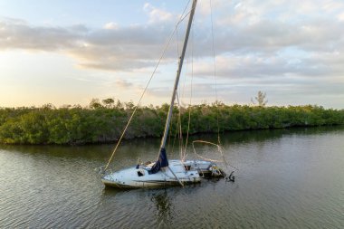 Manasota, Florida 'daki Ian kasırgasından sonra batık yelkenli teknesi sığ körfez sularında terk edildi..