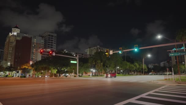 アメリカのワイドマルチレーンストリート交差点は 夜間に交通灯と車を移動します アメリカの交通システム — ストック動画