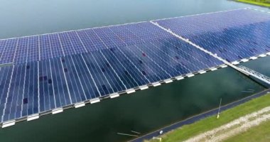 Temiz elektrik enerjisi üretmek için birçok sıra güneş paneli bulunan yüzen fotovoltaik enerji santrali. Su yüzeyinde hava kirliliği olmayan yenilenebilir elektrik kavramı.