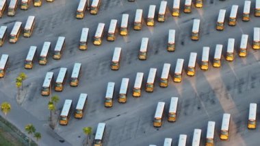 Birçok okul otobüsü ABD 'de ilçe otoparkına park edildi. Amerikan eğitim sistemi ulaşımı.